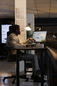 Rear view of woman sitting on table