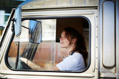 Young female owner driving food truck in city