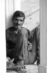 Portrait of a smiling young man sitting on floor