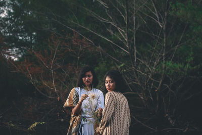 Portrait of young couple standing in forest