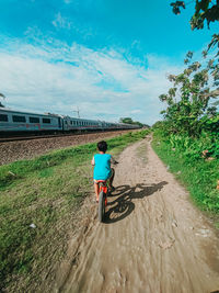 Rear view of man riding motorcycle against sky