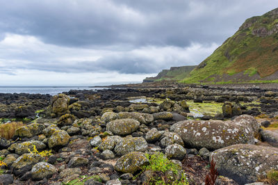 Rocks by sea against sky