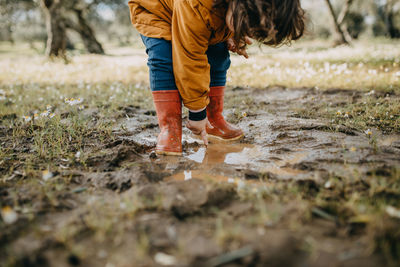 Low section of man standing in mud