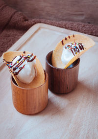 High angle view of dessert with food styling in wooden glasses on table