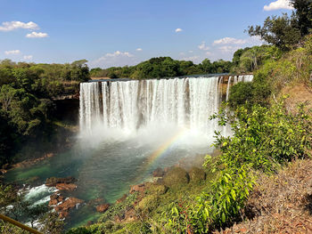 Scenic view of waterfall against sky