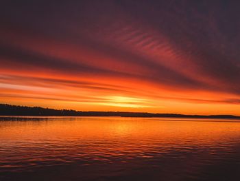 Scenic view of sea against dramatic sky during sunset