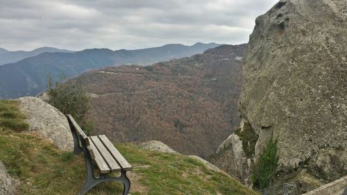 Empty bench against mountains