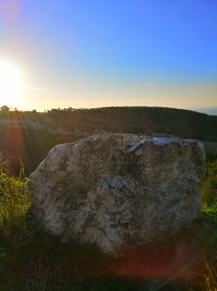 Scenic view of rocks against clear sky during sunset