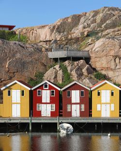 Houses by river against mountain