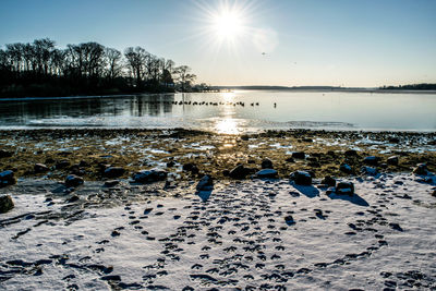 Scenic view of frozen lake against sky during sunset