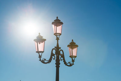 Low angle view of street light against blue sky
