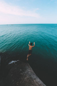 High angle view of shirtless man jumping in sea