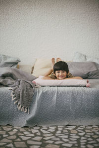 Portrait of smiling girl lying down on sofa at home