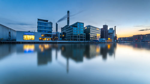 Reflection of buildings in river against sky