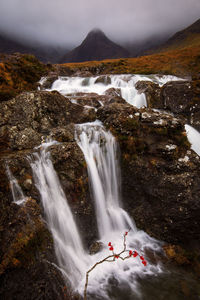 Scenic view of waterfall against sky