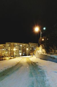 Illuminated city against sky during winter