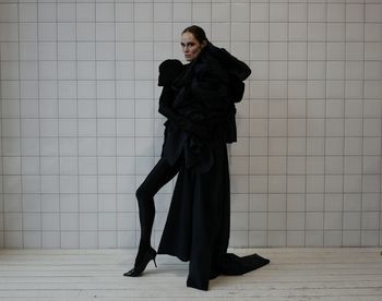 Portrait of woman standing against wall