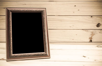 High angle view of blank picture frame on wooden table