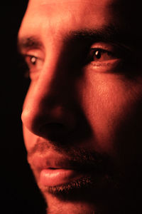 Close-up portrait of young man against black background