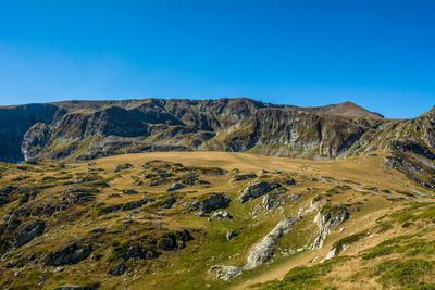 Scenic view of mountains against clear blue sky