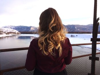 Rear view of woman looking at mountains against sky