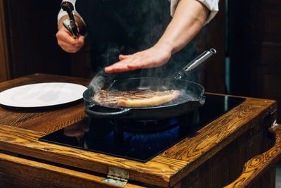 Close-up of man preparing food in restaurant