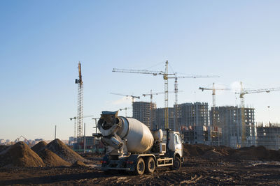 Cranes at construction site against clear sky