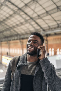 Smiling man talking on phone while looking away