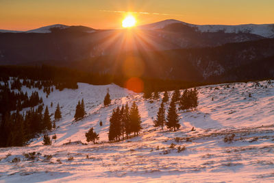 Scenic view of snow mountains against sky during sunset