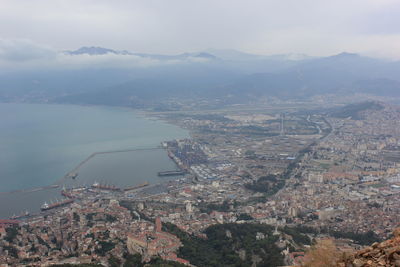 High angle view of buildings by sea against sky