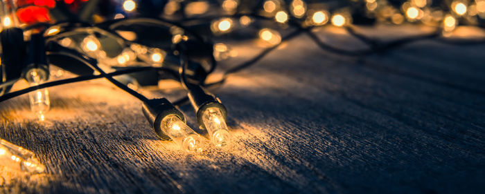 Close-up of illuminated string lights on table during christmas