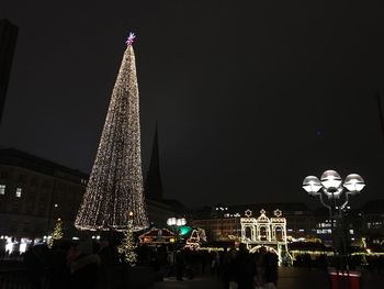 Illuminated christmas tree against sky at night