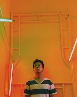 Portrait of young man sitting in illuminated room