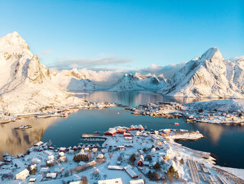 Aerial view of lake by snowcapped mountains against sky