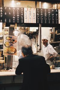 Rear view of people working at restaurant