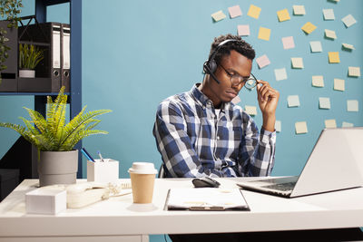 Portrait of young woman using laptop at table