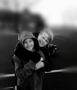 Portrait of smiling grandmother embracing granddaughter at playground