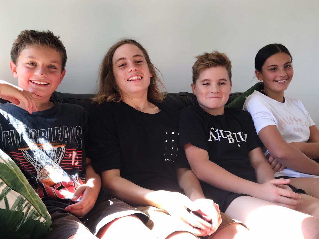 group of people, indoors, boys, sitting, smiling, front view, child, portrait, casual clothing, real people, looking at camera, girls, happiness, emotion, lifestyles, text, teenage boys, childhood, teenager, adolescence, pre-adolescent child, sister
