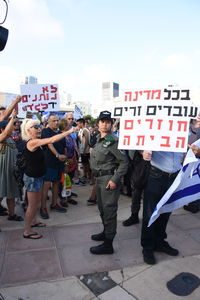 People walking on street in city against sky