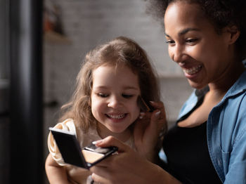 Portrait of smiling girl holding smart phone