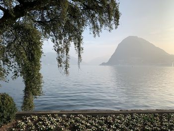 Scenic view of lake by mountains against sky
