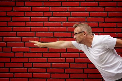 Man standing against brick wall