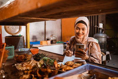 Portrait of young woman preparing food at restaurant