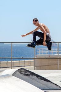 Young man jumping with skates