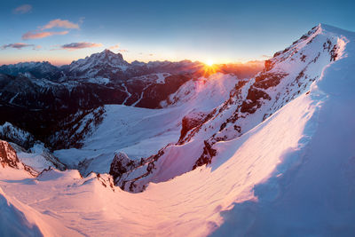 Scenic view of snowcapped mountains against sky during sunset