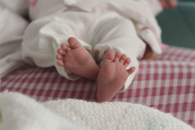 Low section of baby girl on bed