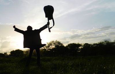 Silhouette man standing on field against sky