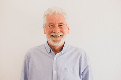 Portrait of smiling man standing against white background