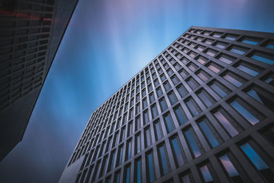 Low angle view of modern building against blue sky