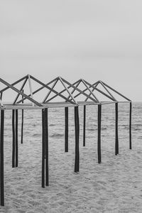 Wooden posts on beach against clear sky